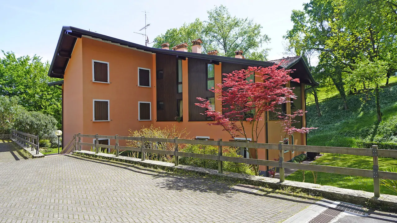 Esterno del complesso residenziale con alberi e vialetto