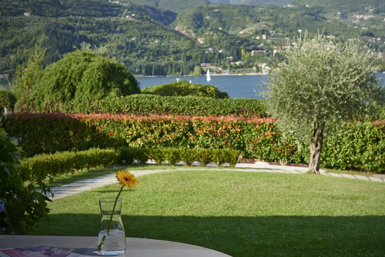 Garten mit Rasen, Hecken und Seeblick im Hintergrund
