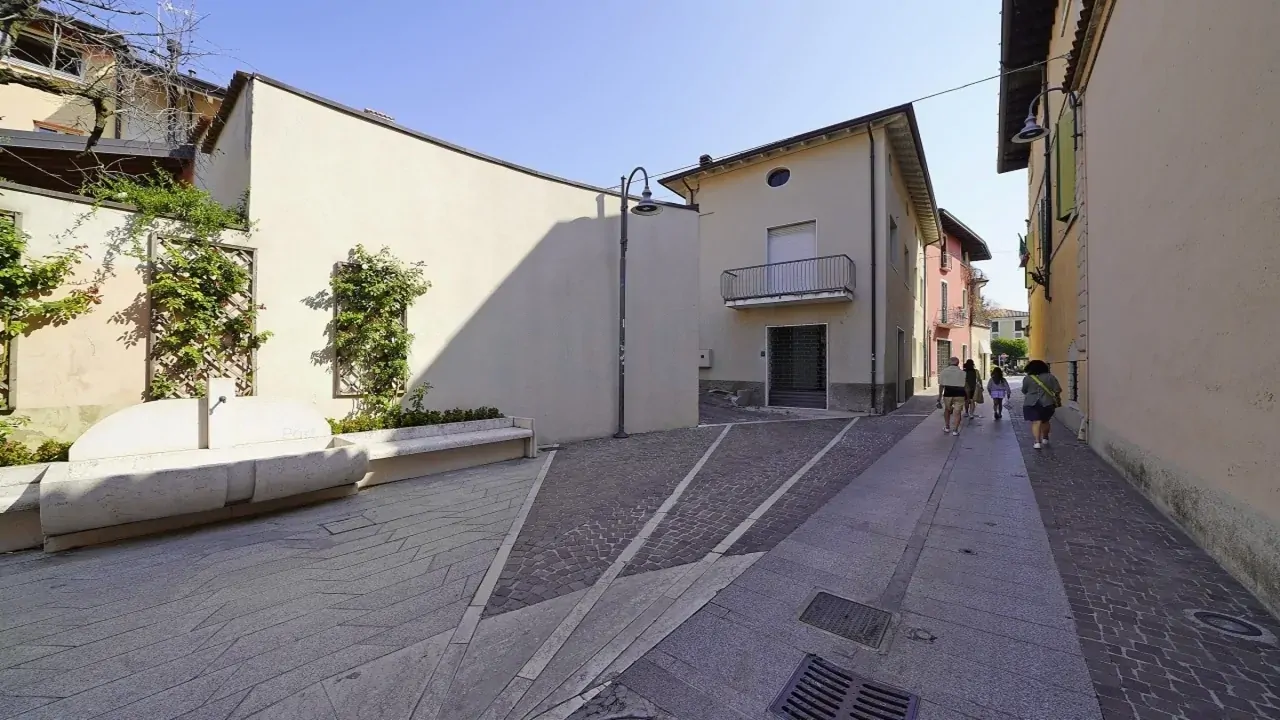 Fußgängerstraße mit Bänken und Gebäuden in Moniga del Garda