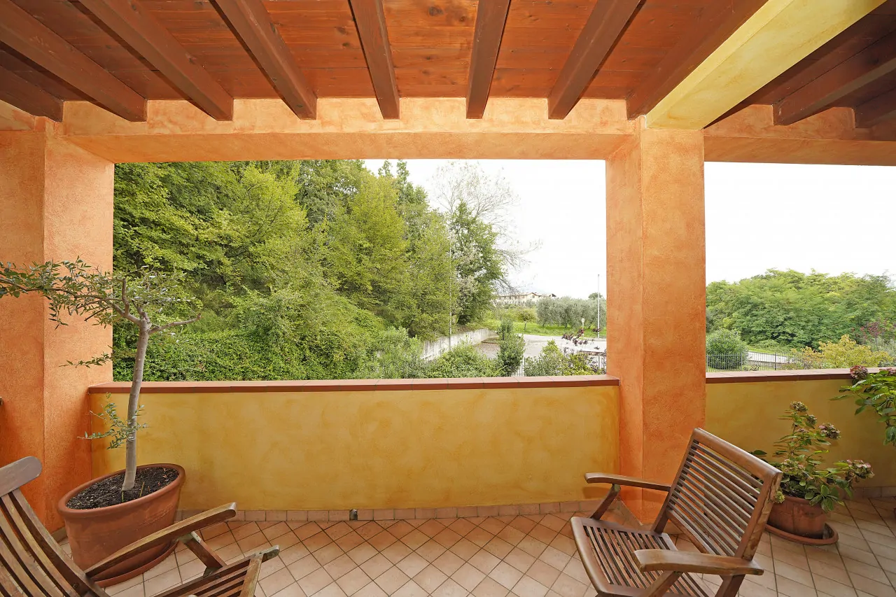 Terrazza coperta con sedie in legno e piante in vaso