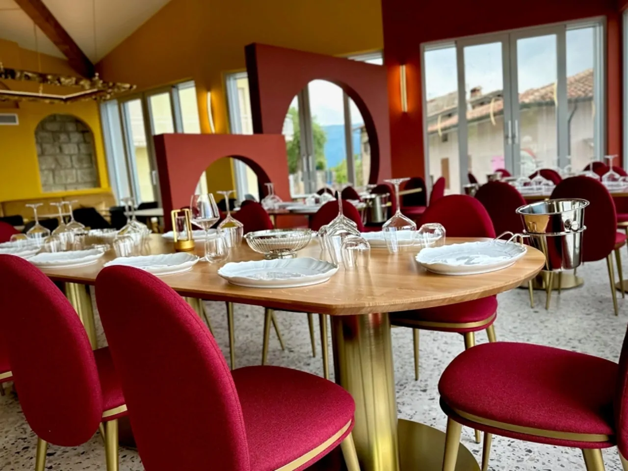 Tavolo apparecchiato con sedie rosse in ristorante