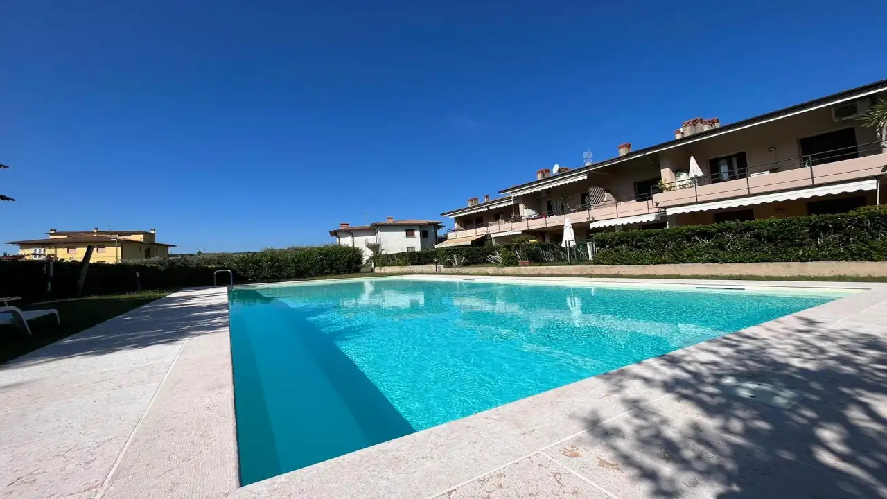 Piscina esterna con bordo in pietra e cielo sereno