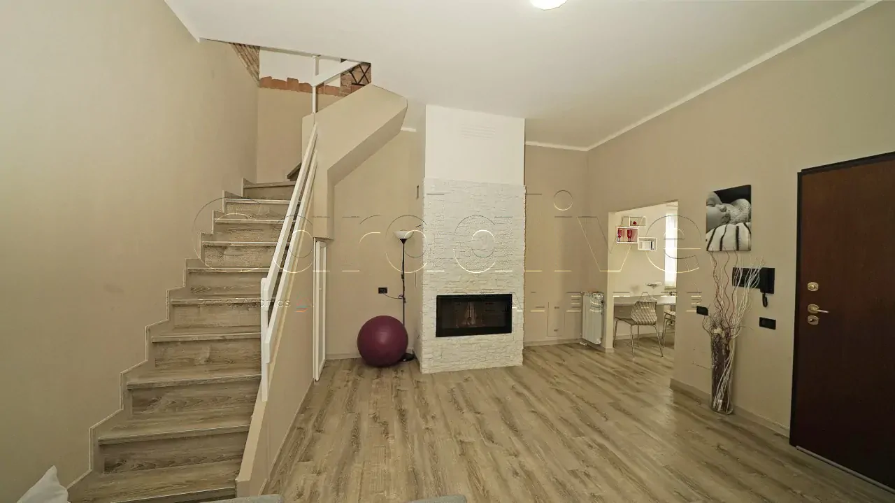 Wohnzimmer mit Innentreppe und modernem Kamin