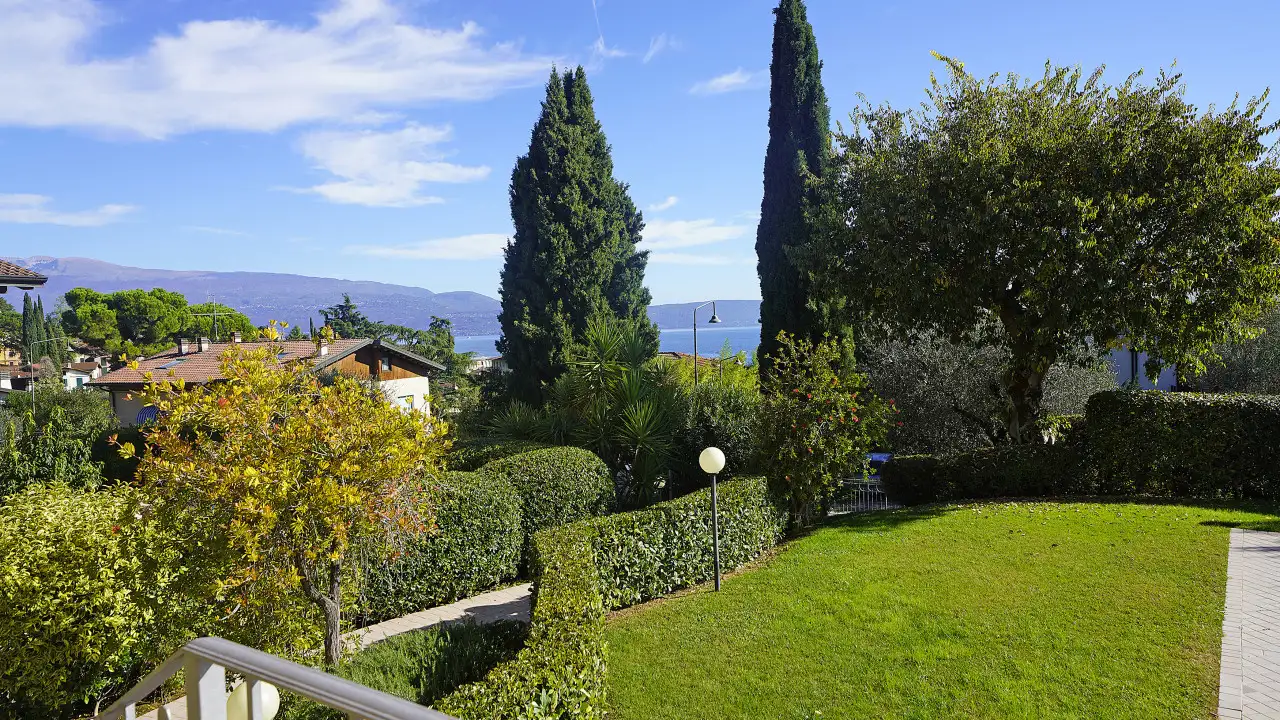 Giardino con prato e alberi con scorcio sul lago