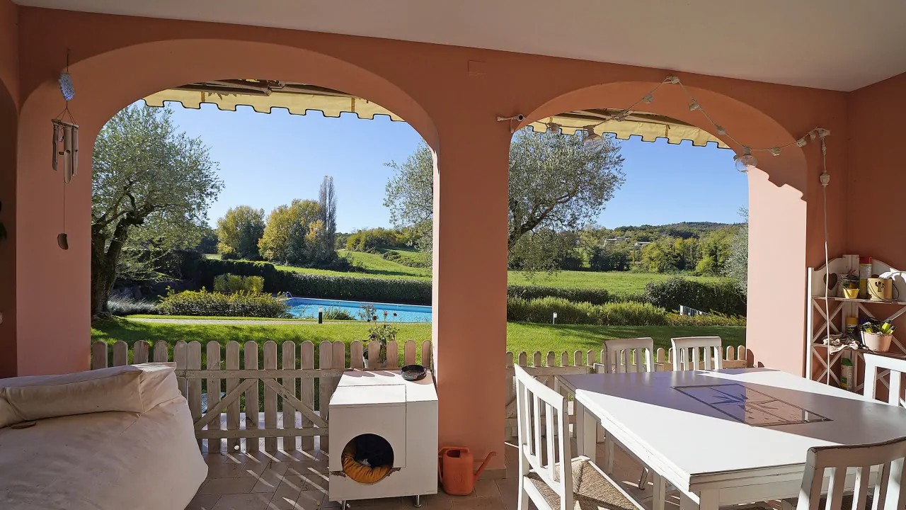 Terrazza coperta con vista su piscina e giardino