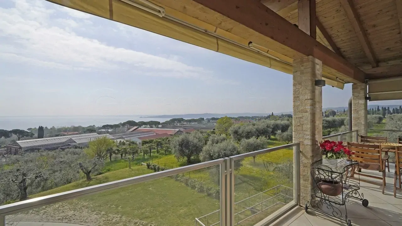 Überdachte Terrasse mit Blick auf Garten und See
