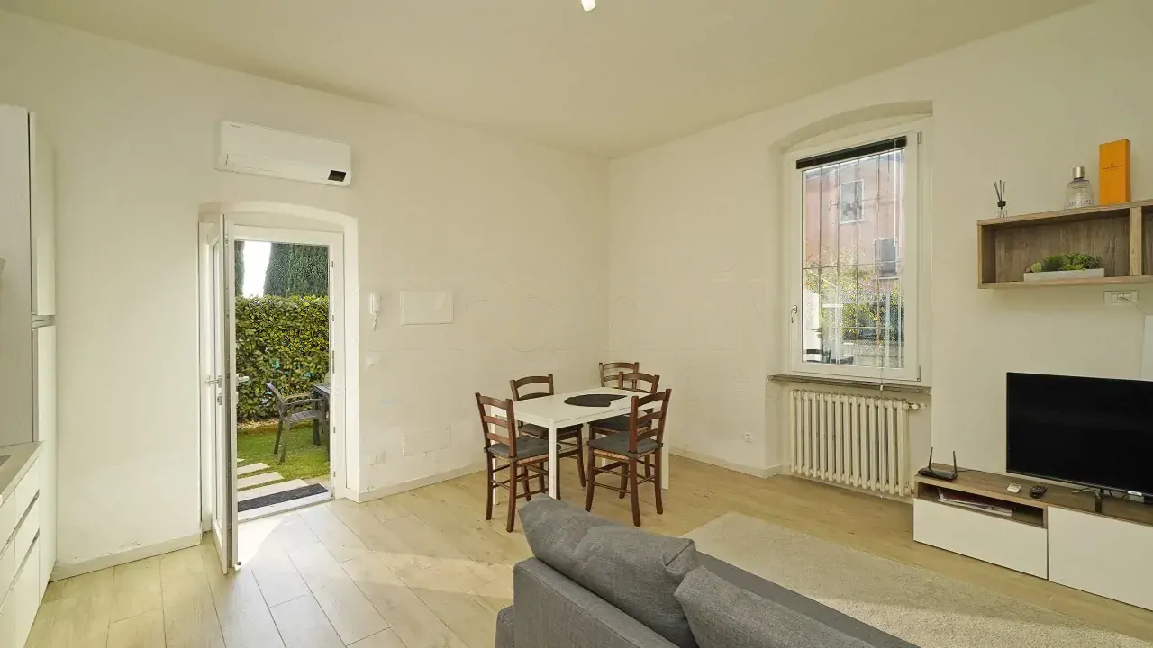 Wohnzimmer mit Esstisch und Tür zum Garten