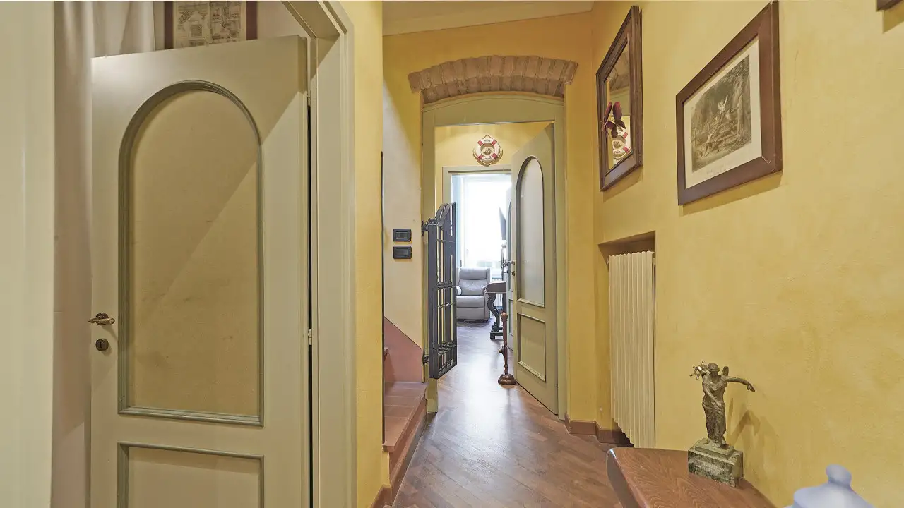 Ingresso con porta ad arco e pavimento in legno