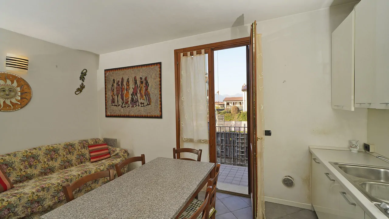 Living room with floral sofa and glass door to balcony