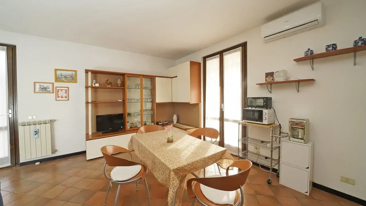 Wohnzimmer mit Esstisch und Schrank mit Fernseher