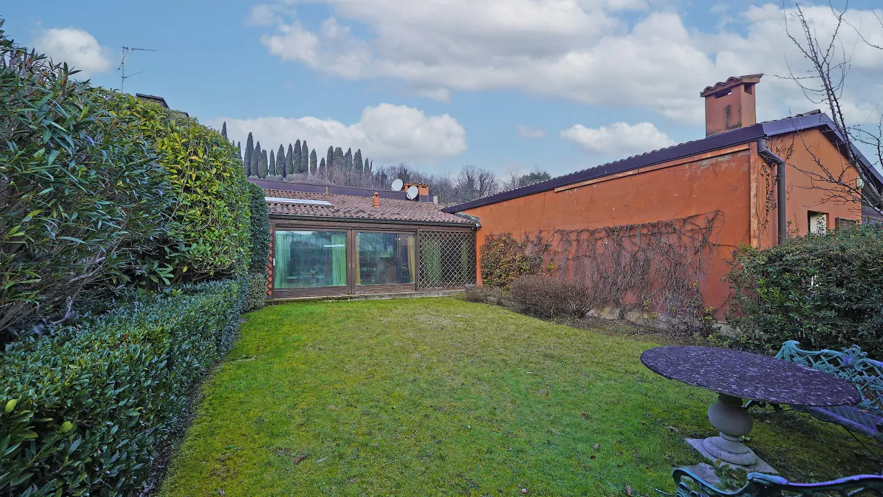 Giardino privato con siepi e tavolo in ferro battuto