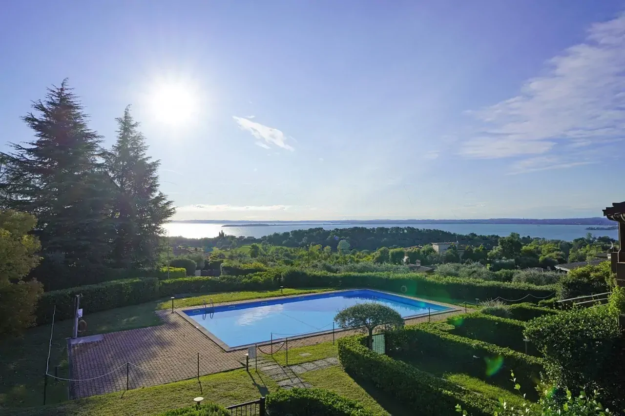 Outdoor swimming pool with lake view and clear sky