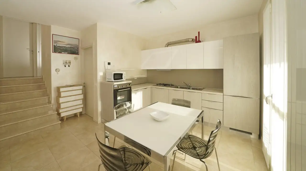 Cucina con tavolo e sedie vicino a scala interna