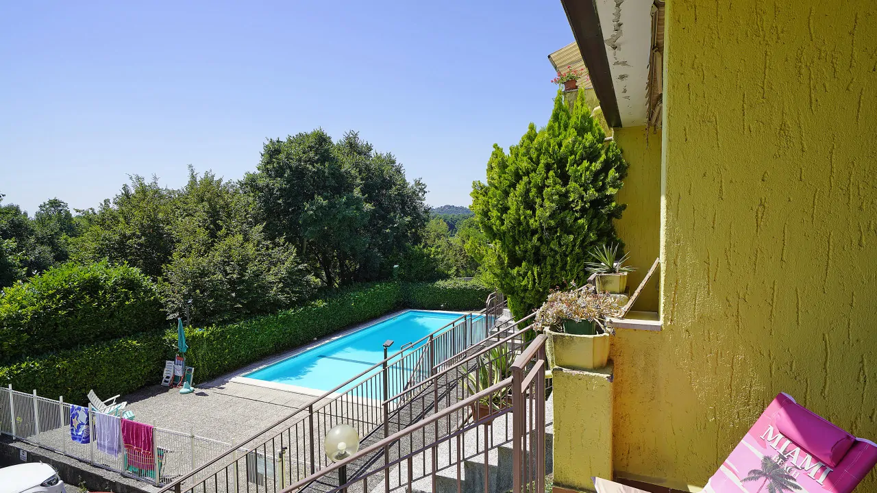 Outdoor swimming pool with fence and surrounding greenery