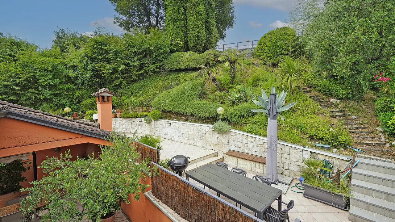 Terrace with table and chairs and garden with stone steps