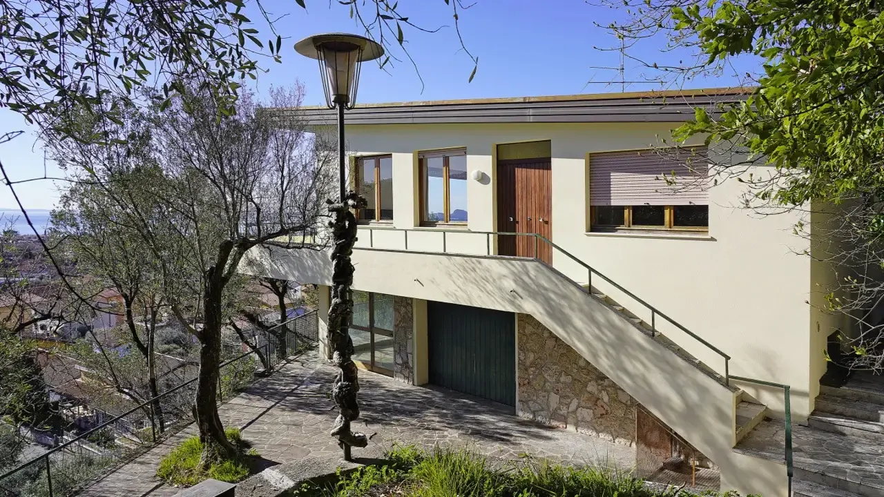 Villa-Fassade mit Außentreppe und teilweisem Seeblick