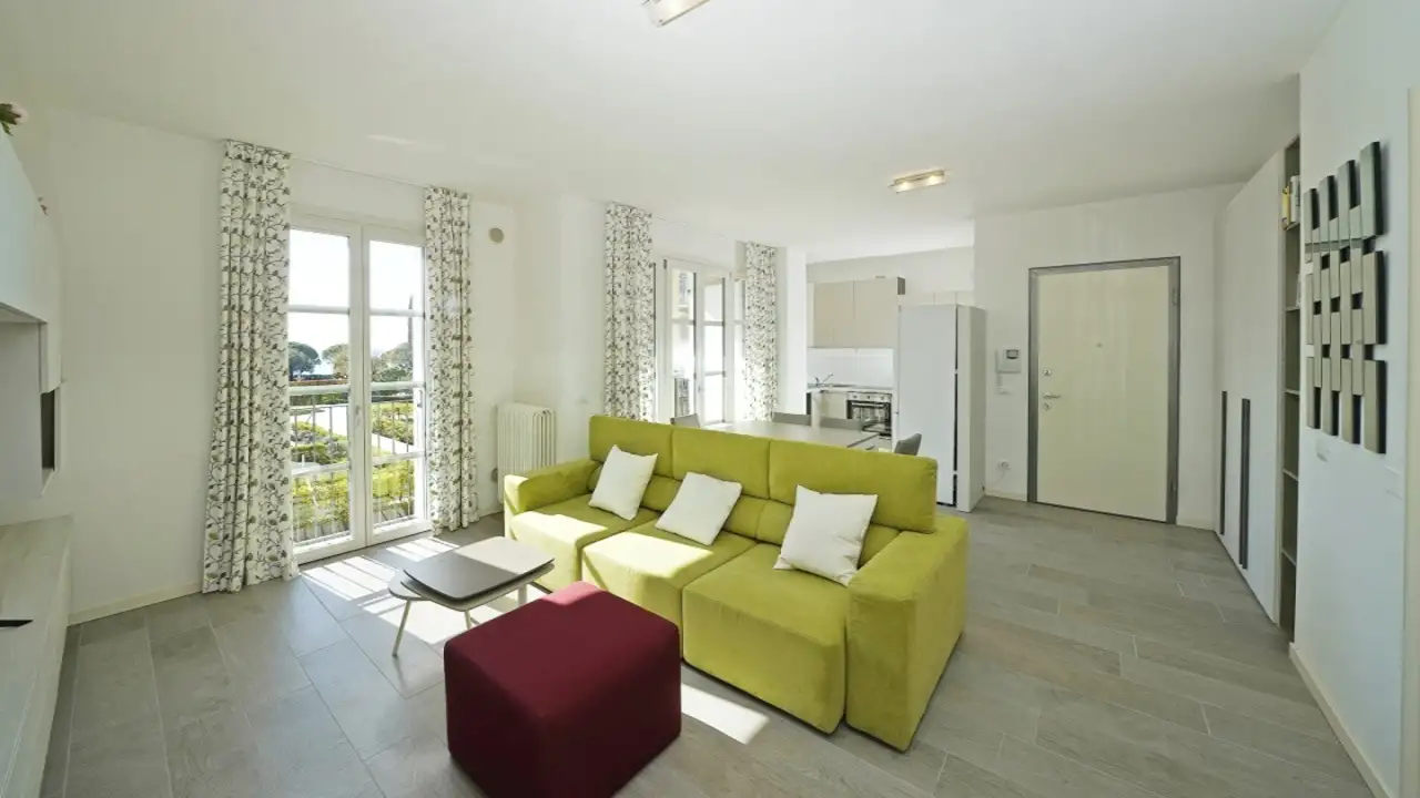 Living room with green sofa and red armchair near French doors