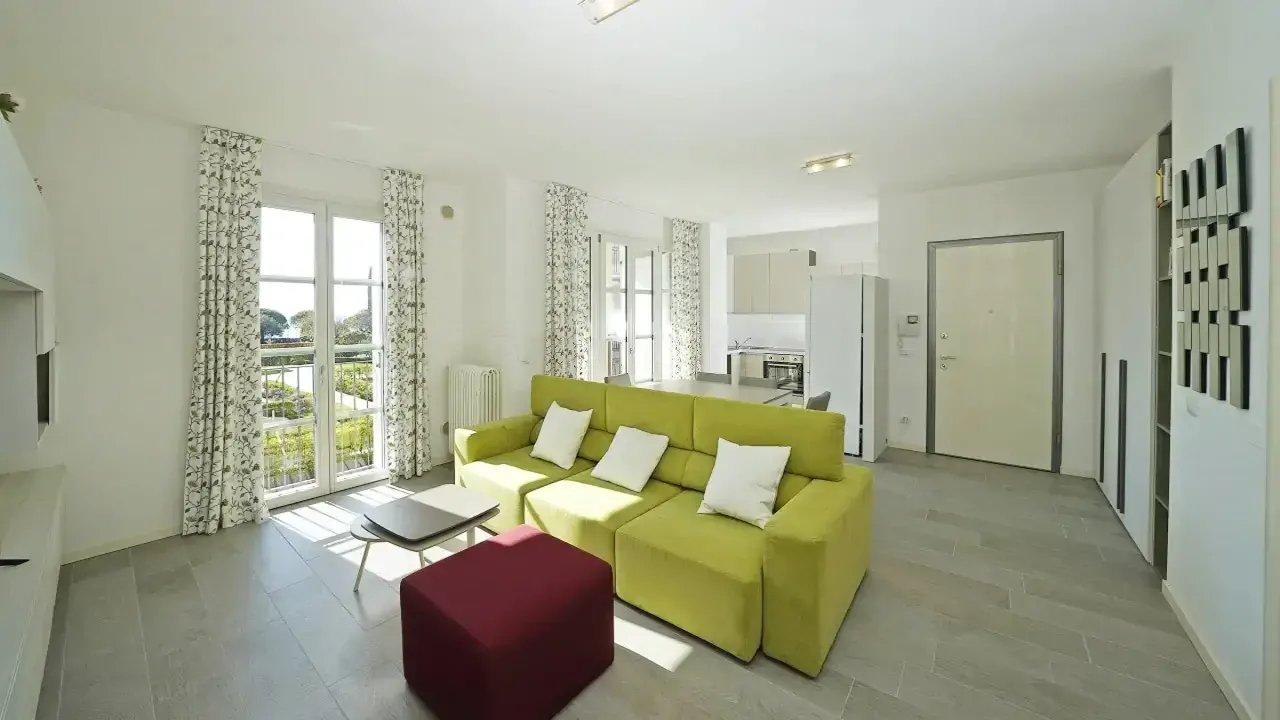Living room with green sofa and red armchair near French doors