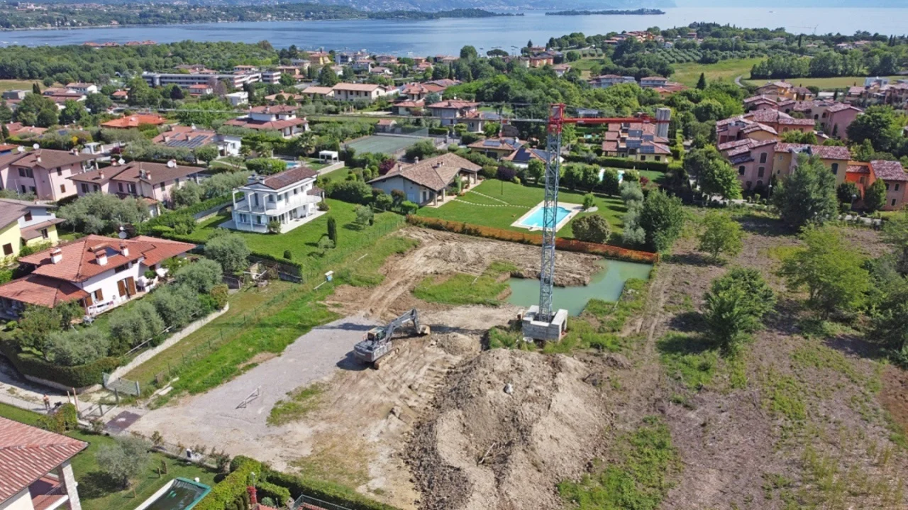 Construction site with crane and excavator in green area in Manerba del Garda