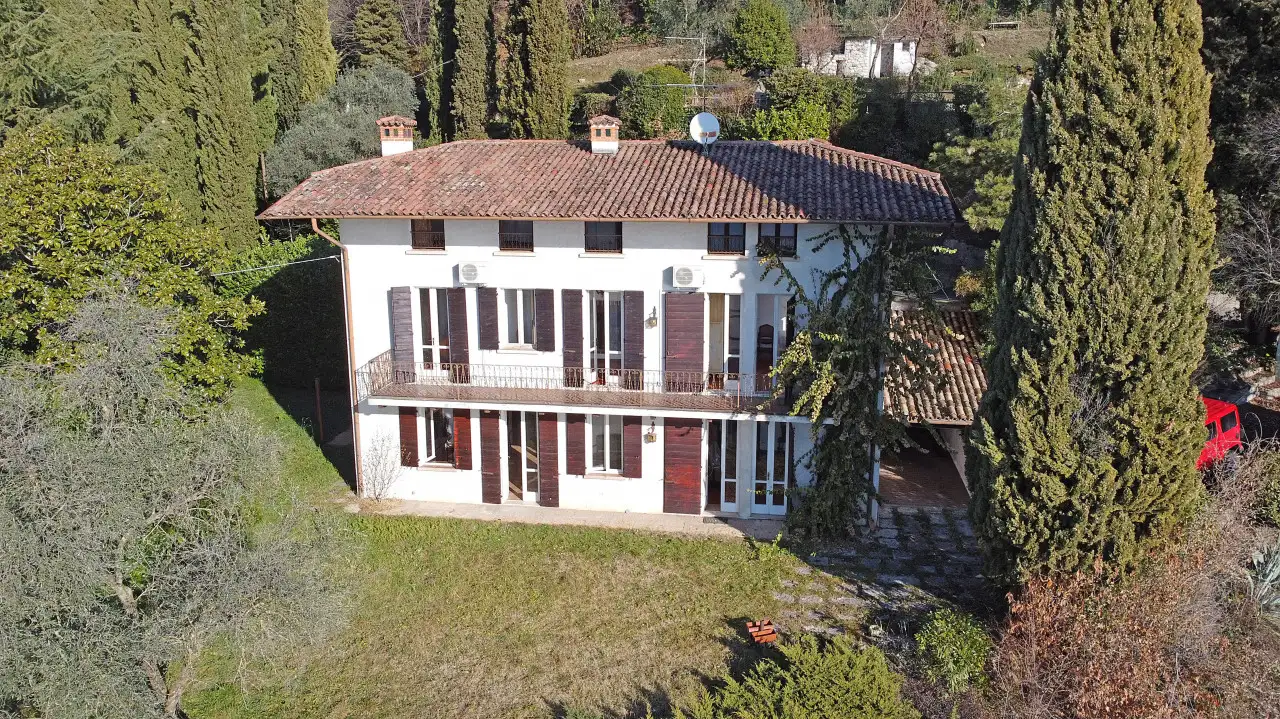 Villa singola con giardino e alberi intorno
