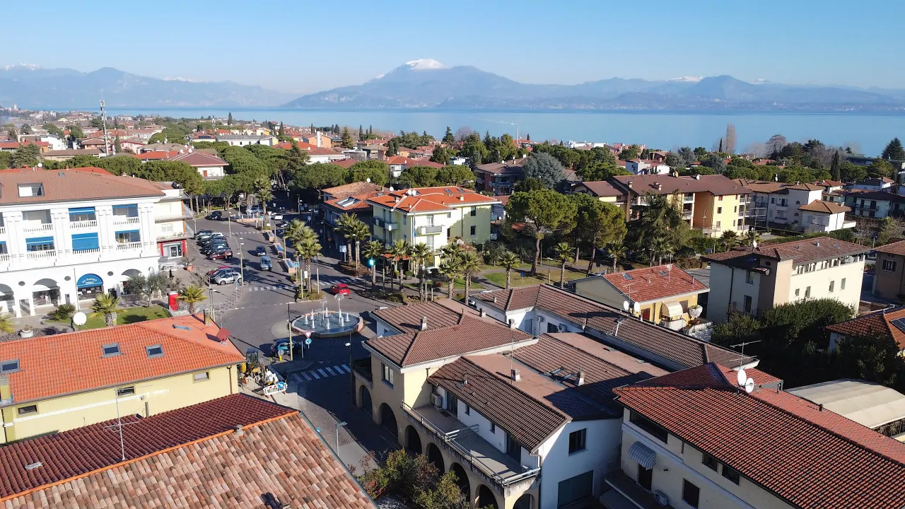 Vista aerea del centro di Sirmione con il lago e le montagne sullo sfondo