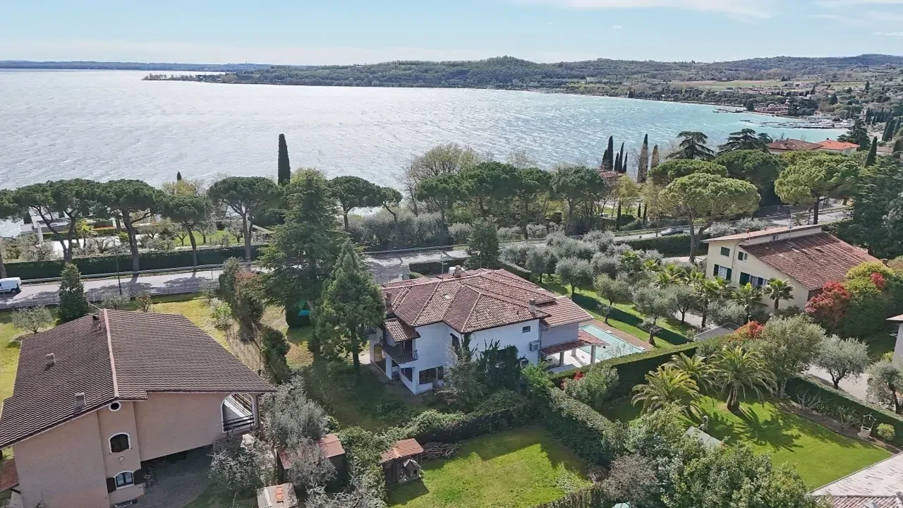 Vista aerea sul lago e case con giardini a Padenghe sul Garda
