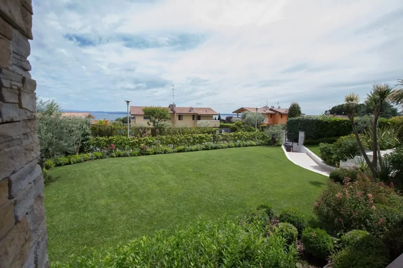 Giardino con prato e siepi con vista sul lago