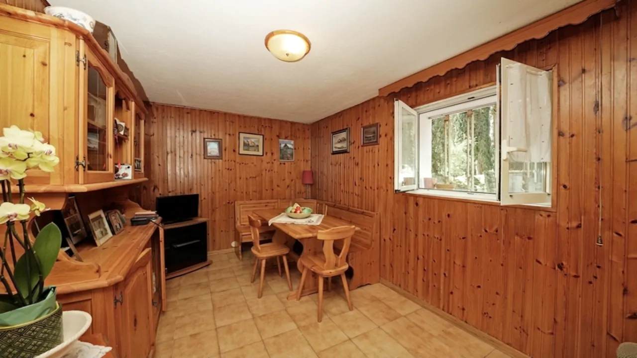 Soggiorno con pareti in legno e tavolo con sedie