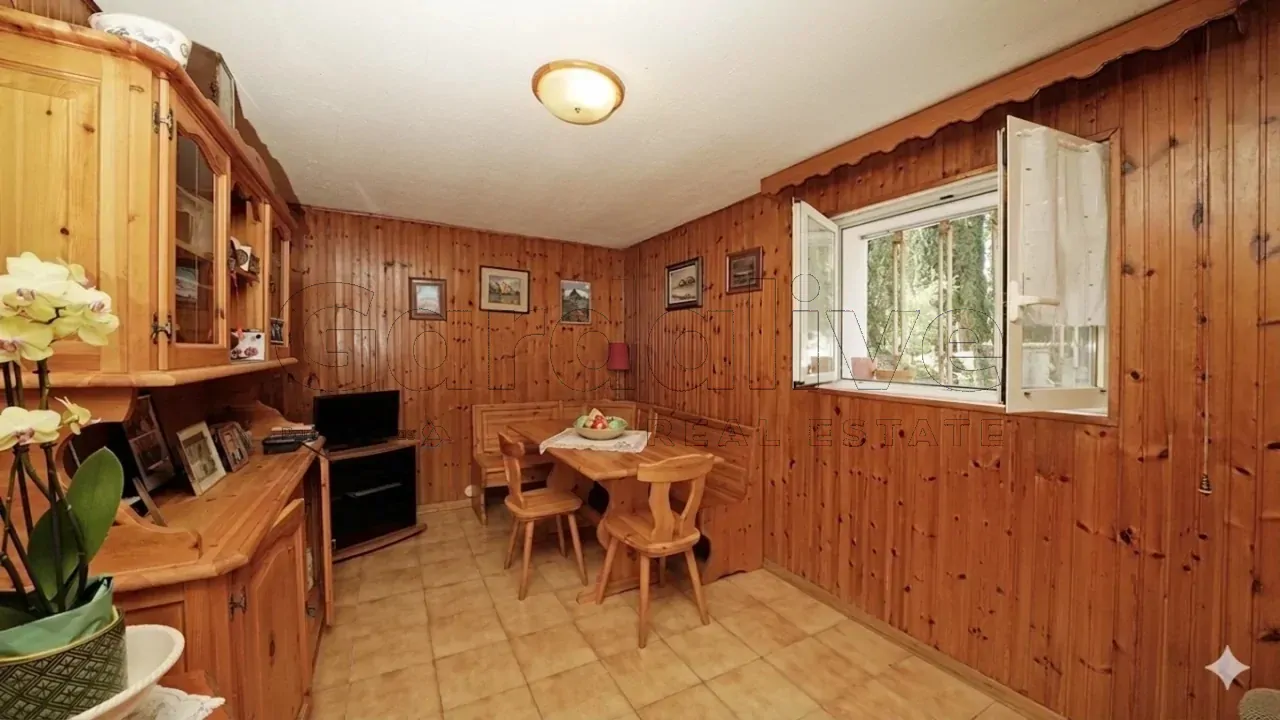 Wohnzimmer mit Holzwänden und Tisch mit Stühlen