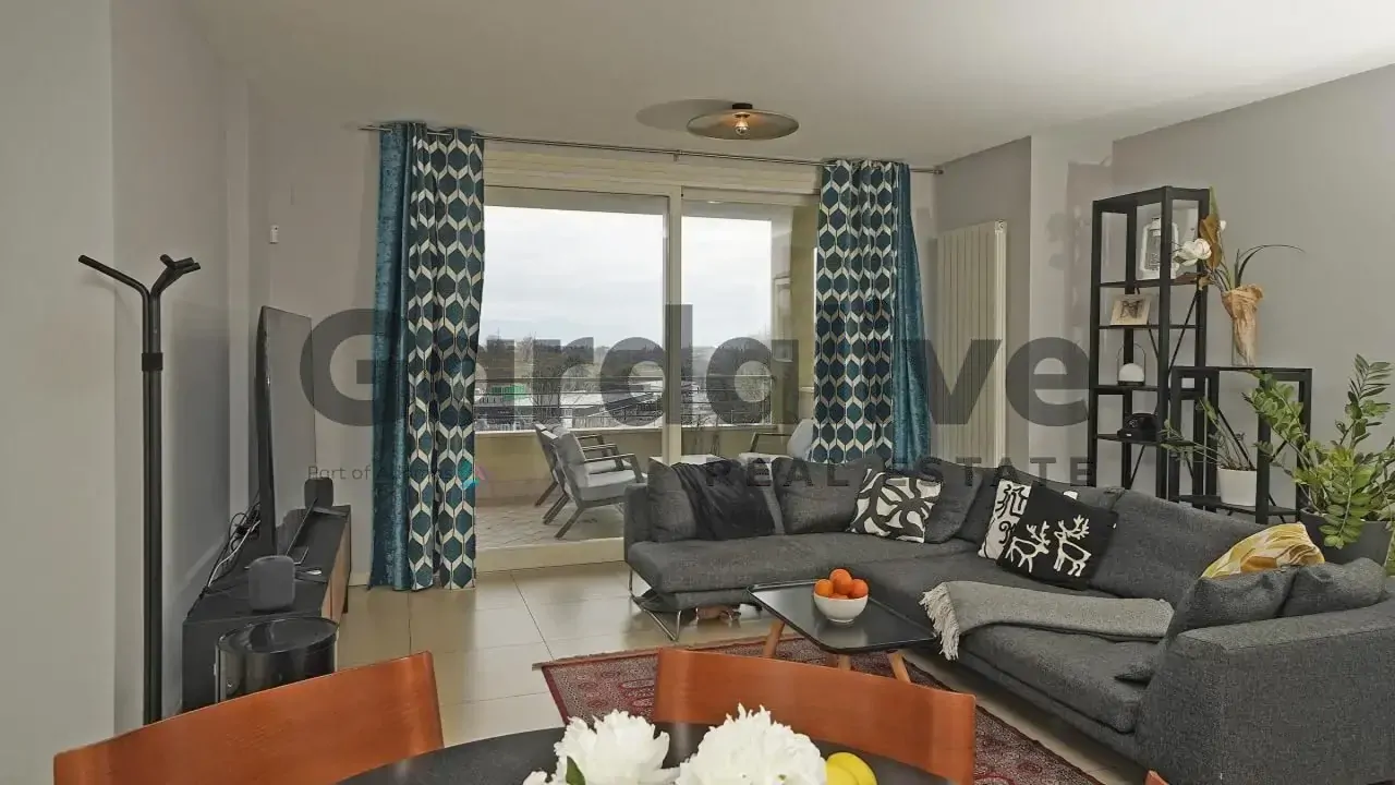 Living room with corner sofa and glass door to balcony