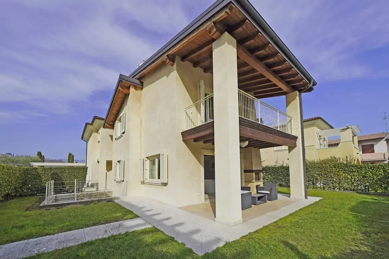 Außenansicht der Villa mit Garten und überdachtem Balkon