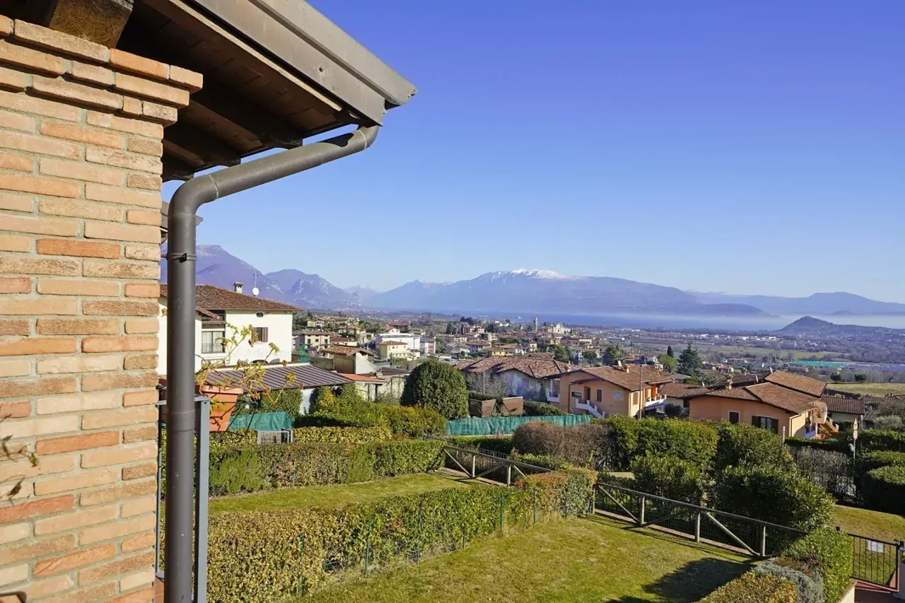 Vista panoramica su giardini, case e montagne sullo sfondo