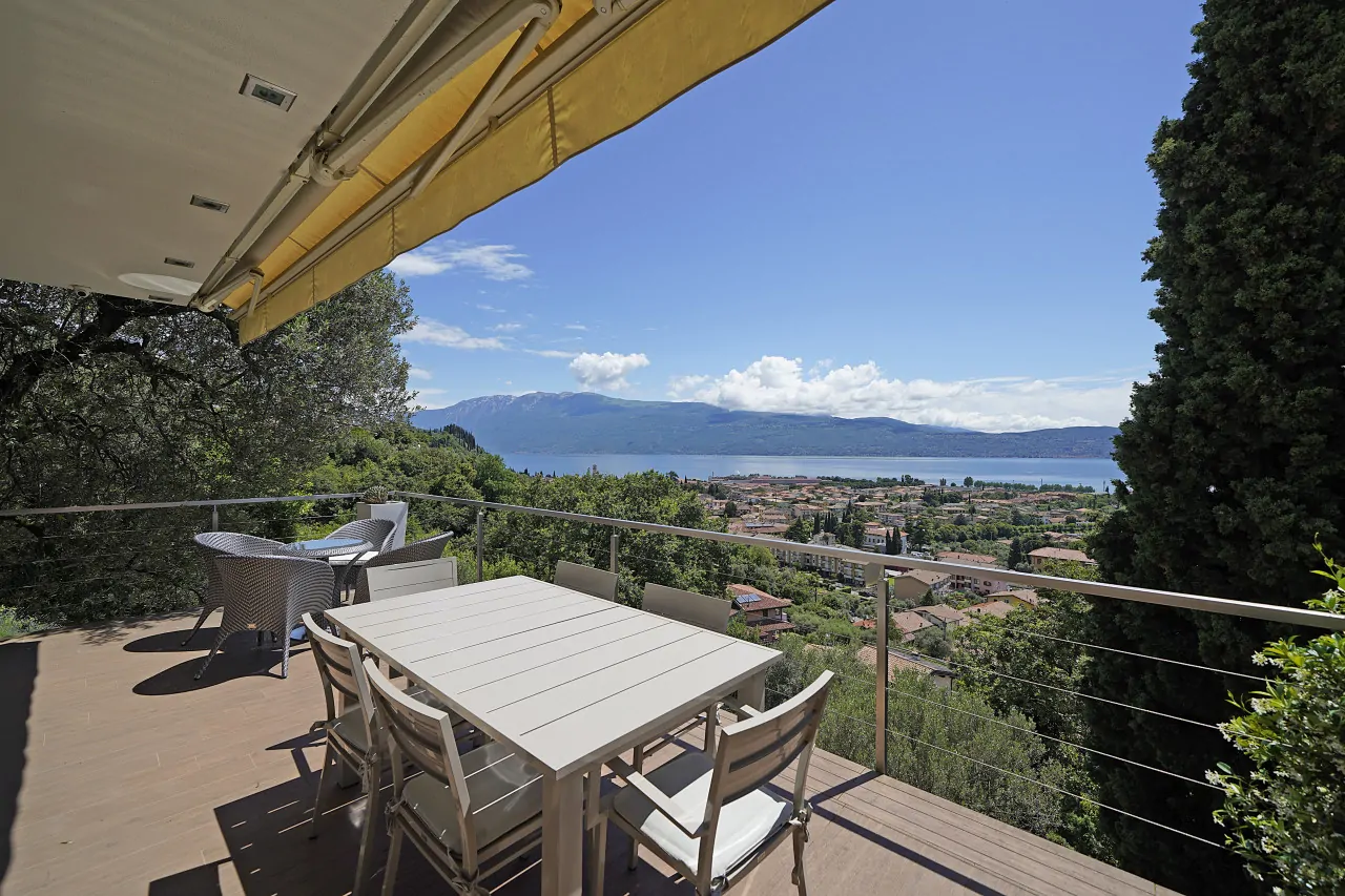 Terrasse mit Tisch und Stühlen mit Blick auf den See und die Landschaft