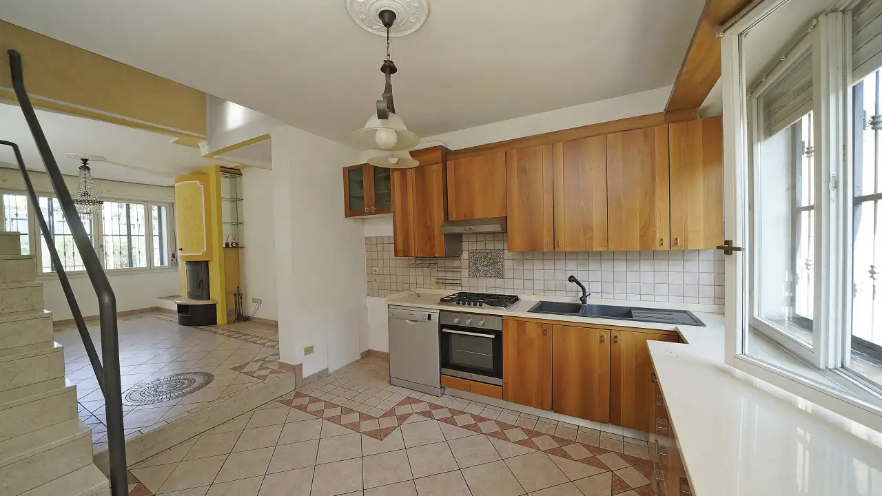 Cucina con mobili in legno e finestra aperta