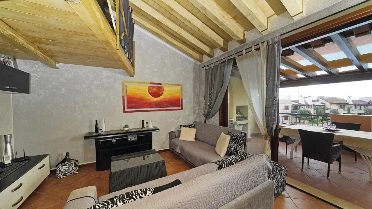 Soggiorno con divani e accesso alla terrazza coperta