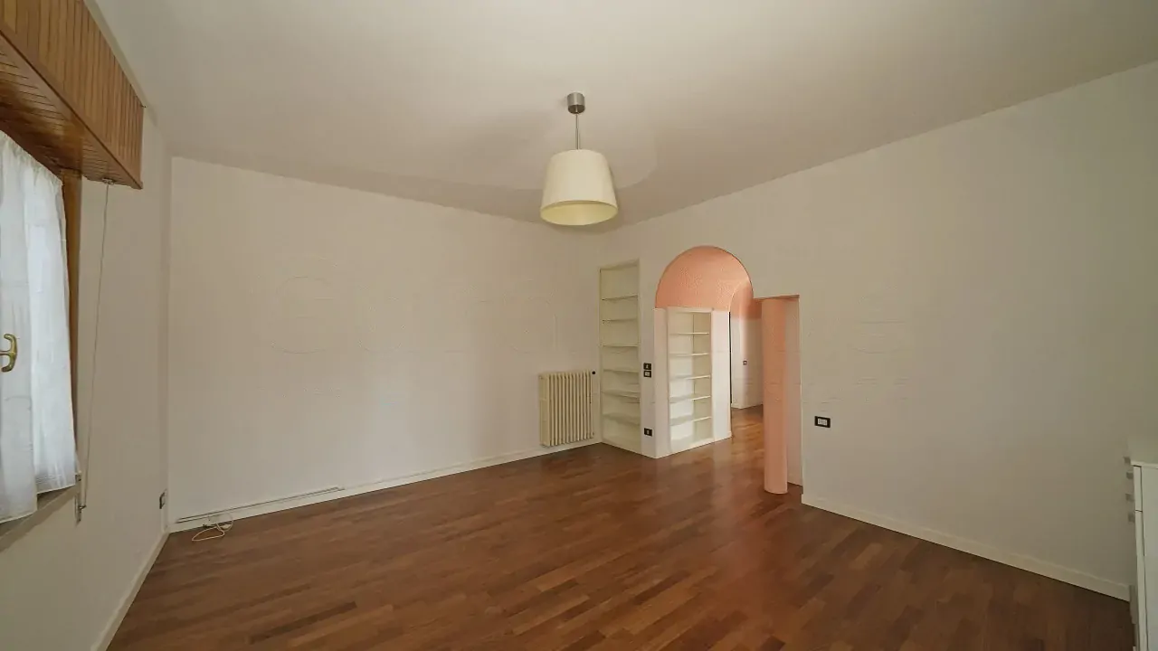 Soggiorno con pavimento in legno e pareti bianche