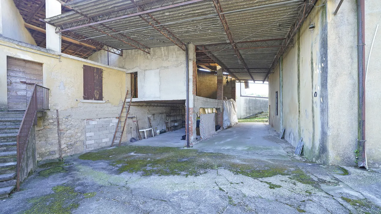 Cortile esterno con copertura e pareti in cemento e pietra
