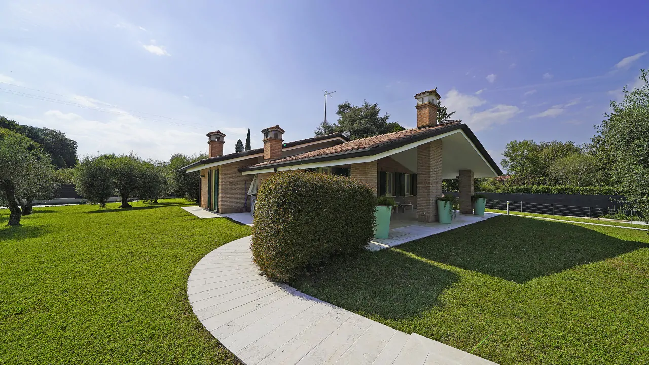 Villa singola con giardino e vialetto curvo