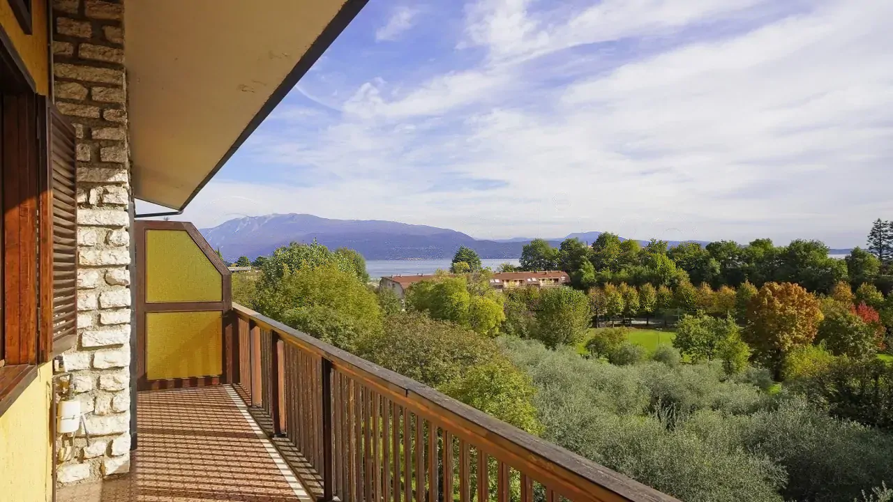 Terrazza con ringhiera in legno e vista sul lago e montagne
