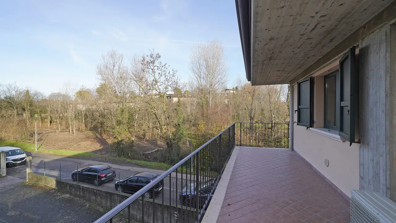 Terrasse mit Geländer mit Blick auf Parkplatz und Bäume