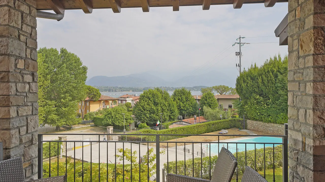 Covered terrace with view of the pool and lake