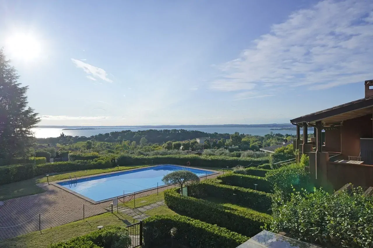 Outdoor swimming pool with lake view and surrounding garden