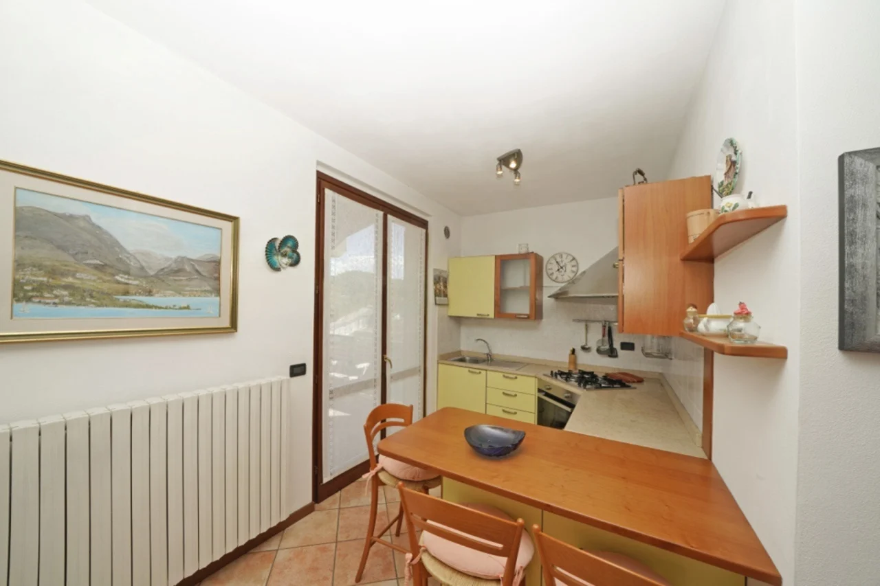 Cucina con tavolo e sedie vicino a porta finestra