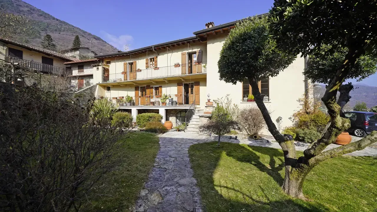 Privater Garten mit Baum und Steinweg vor historischem Haus