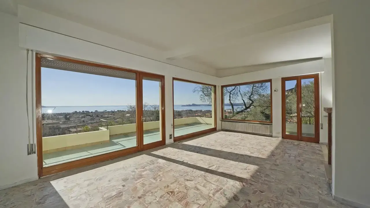 Wohnzimmer mit großen Fenstern und Seeblick