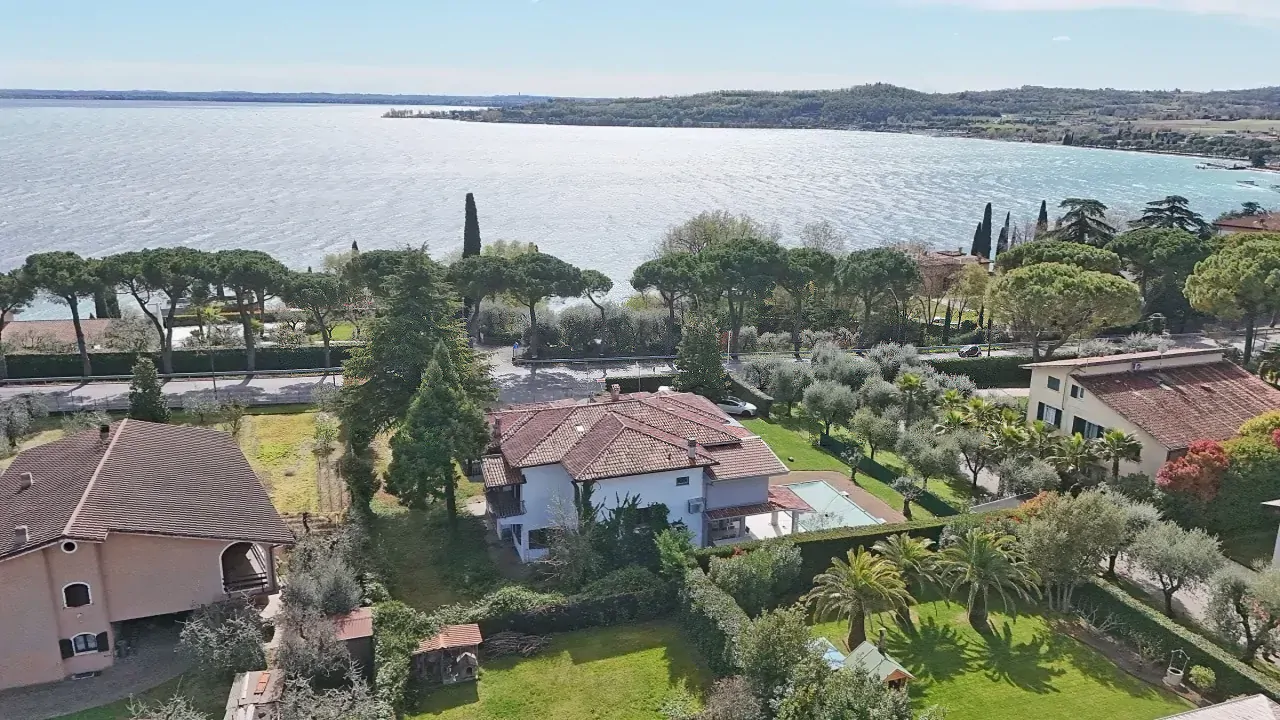 Vista aerea sul lago e case con giardini a Padenghe sul Garda