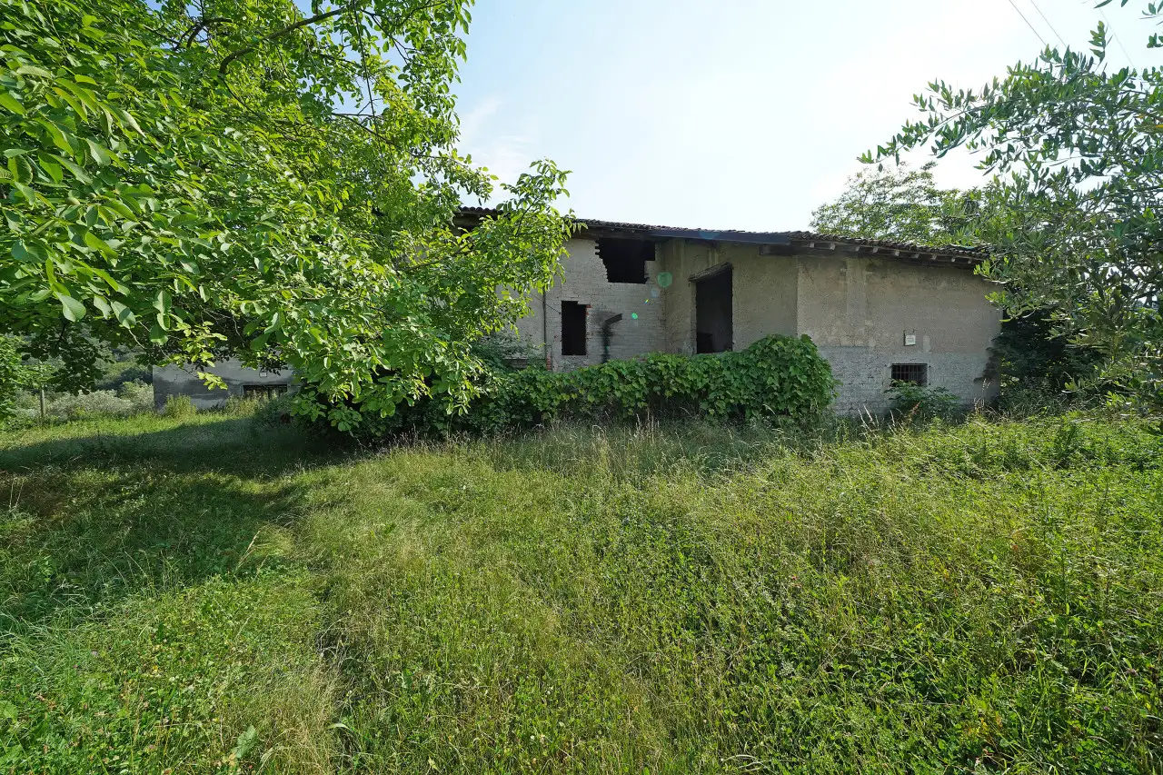 Rustico da ristrutturare con terreno e vegetazione intorno