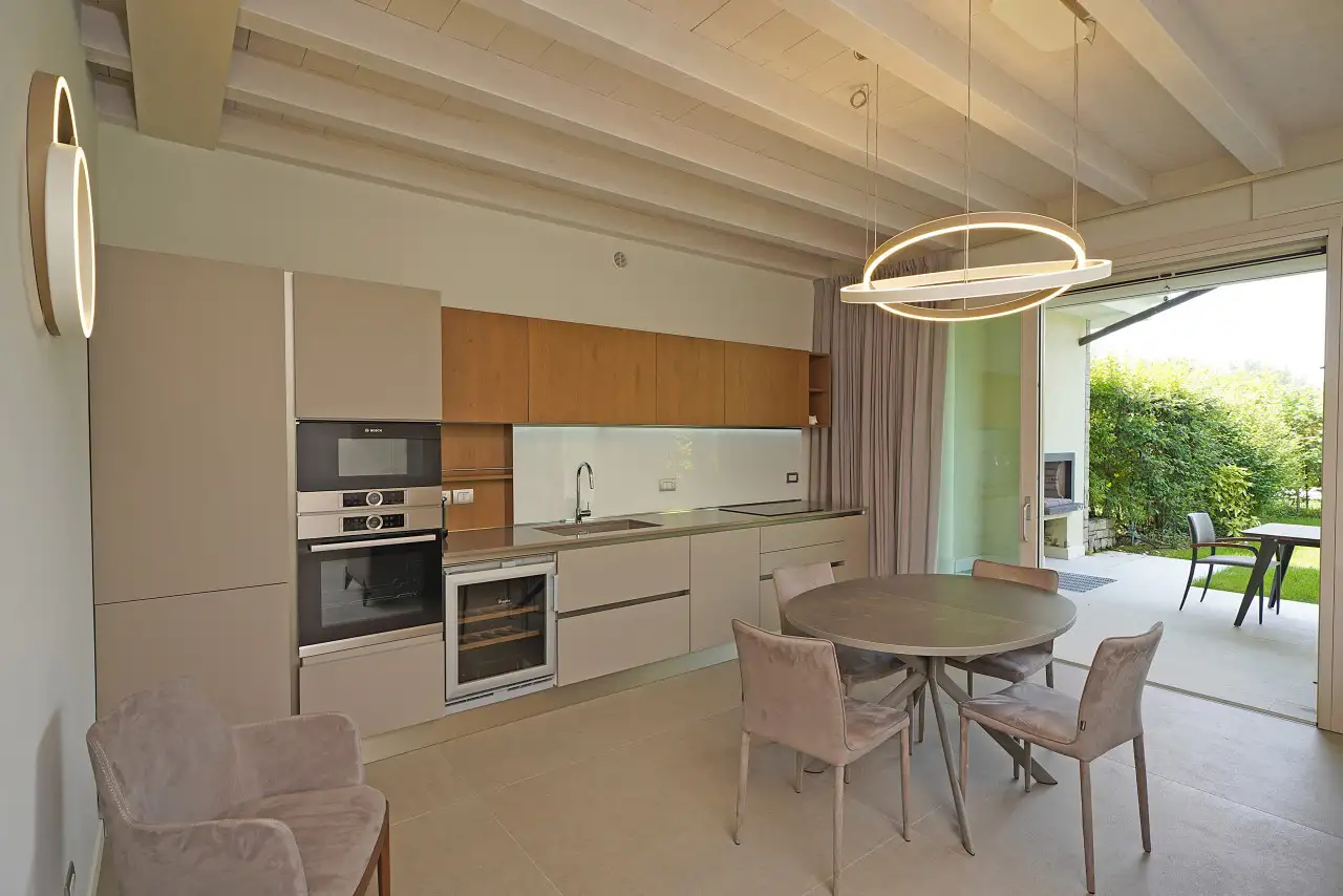 Modern kitchen with round table and access to garden