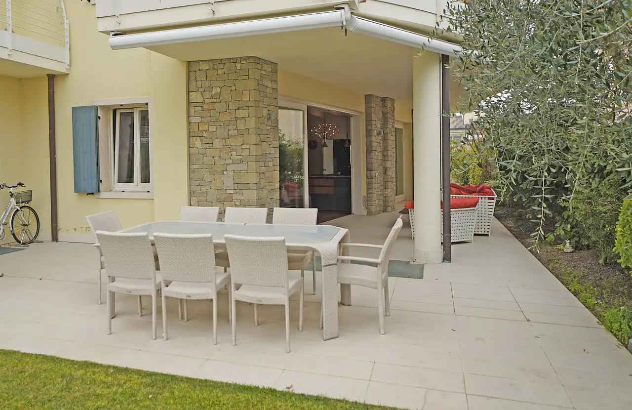 Terrazza con tavolo da pranzo e divani esterni