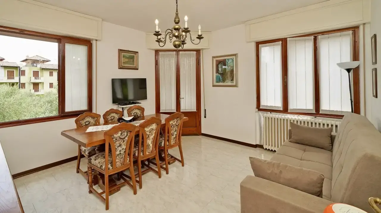 Living room with dining table and sofa near windows